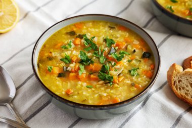 Homemade fresh lemon rice soup in a bowl, side view.