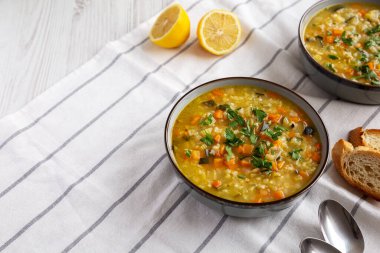Homemade fresh lemon rice soup in a bowl, side view. Copy space.