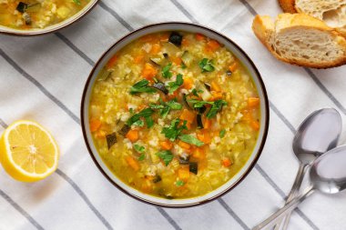 Homemade fresh lemon rice soup in a bowl, top view. Flat lay, overhead, from above.