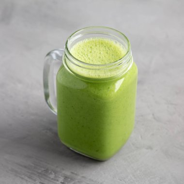 Homemade Greek Yogurt Green Smoothie with Spinach and Banana in a Jar, side view.