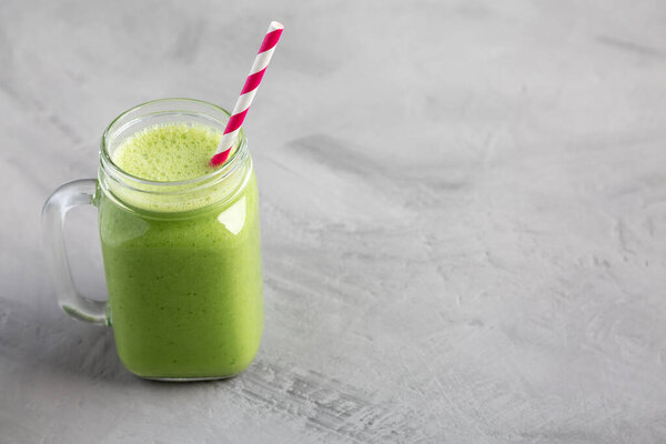 Homemade Greek Yogurt Green Smoothie with Spinach and Banana in a Jar, side view. Copy space.