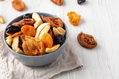Organic healthy fruit mix in a bowl, side view. Space for text.
