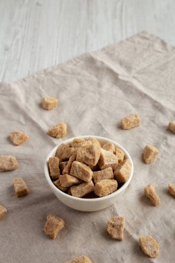 Raw Organic Demerara Granulated Brown Sugar in a Bowl, side view. Copy space.