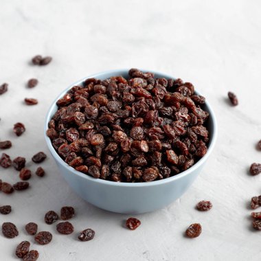 Dried Brown Raisins in a Bowl, side view.