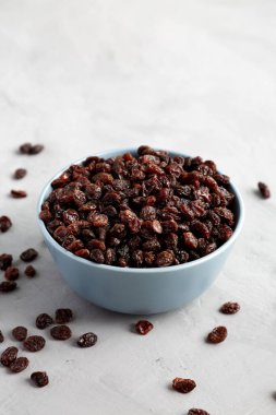 Dried Brown Raisins in a Bowl, side view. Copy space.