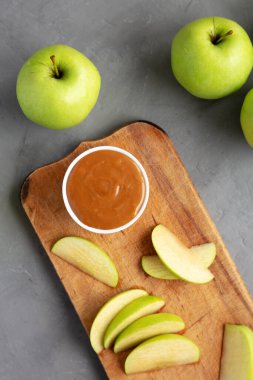 Ev yapımı karamelli elma sosu, ahşap bir tahta üzerinde, üst manzara. Dümdüz, tepeden, yukarıdan.