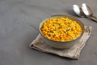 Ev yapımı Yavaş Pişiren Kremalı Mısır Kasesi gri arka planda, kenar manzaralı. Boşluğu kopyala.