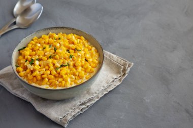 Ev yapımı Yavaş Pişiren Kremalı Mısır Kasesi gri arka planda, kenar manzaralı. Boşluğu kopyala.