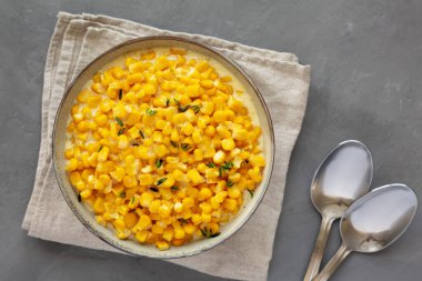 Ev yapımı Yavaş Pişiren Kremalı Mısır Kasesi gri arka planda, üst manzara. Dümdüz, tepeden, yukarıdan. Yakın plan..