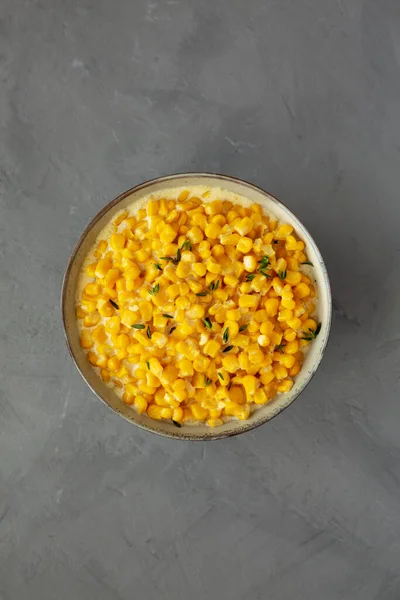 Homemade Slow Cooker Creamed Corn in a Bowl on a gray background, top view. Flat lay, overhead, from above.