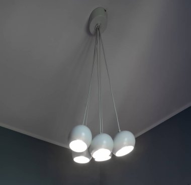 Yatak odasının gri tonlarında modern bir iç mekan. Şık bir avizeyle tavan manzarası.