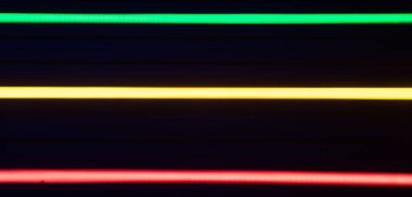 Bulanık neon ışık çizgileri. Yeşil, sarı ve kırmızı renkler.