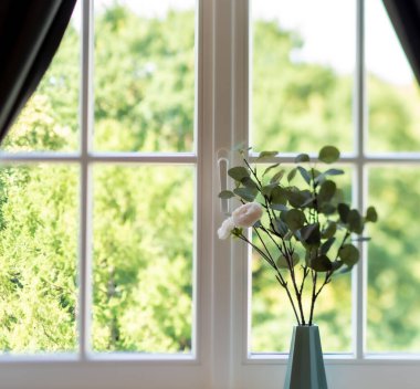 Pencere pervazında vazodaki çiçekler. Yakın plan. Konforlu daire.