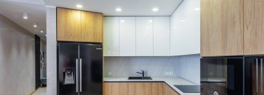 Dairenin modern aydınlık ahşap mutfağı. Beyaz dolaplar.