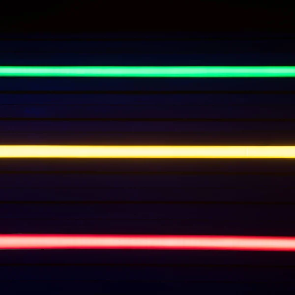 Bulanık neon ışık çizgileri. Yeşil, sarı ve kırmızı renkler. — Stok fotoğraf