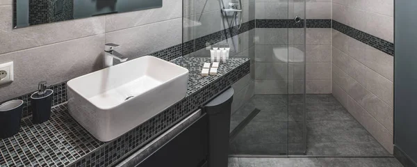 Modern dairede banyonun modern iç mekanı. Gri renkler. Beyaz lavabo Cam duş kabini.. — Stok fotoğraf