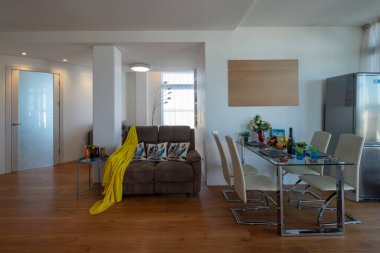 Modern stüdyo daire içi. Sıcak bir kanepe. Masa ve sandalyeler. Buzdolabı.