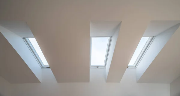 Modern iç mekan. Eğimli çatıdaki pencereler. Beyaz tavan. — Stok fotoğraf