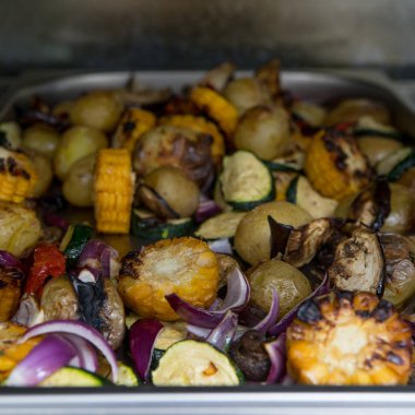 Izgara mısır, soğan, mantar, metal tabakta kabak. Restoranın mutfağı..