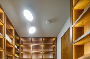 Lüks apartmandaki vestiyerin modern iç mekanı. Ahşap raflar.
