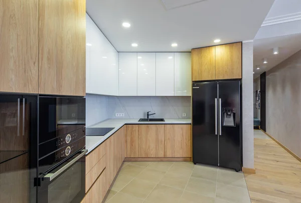 Μοντέρνο εσωτερικό του φωτός ξύλινη κουζίνα στο διαμέρισμα. Λευκά ερμάρια. — Φωτογραφία Αρχείου