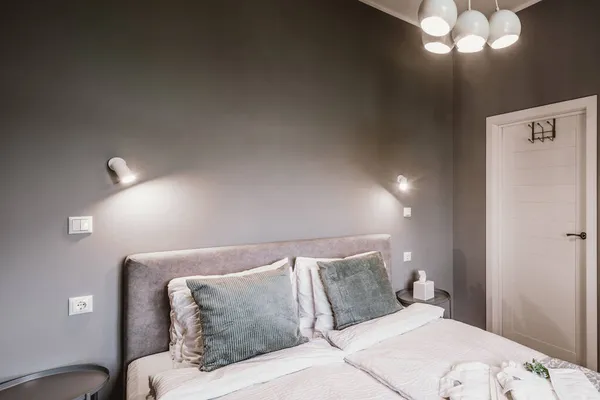 Interior contemporâneo do quarto em cores cinza. Apartamento moderno. Cama queen size. Porta fechada. — Fotografia de Stock