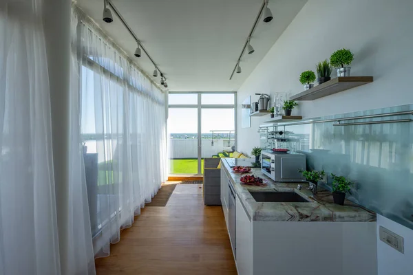 Современный кухонный интерьер в роскошной однокомнатной квартире. Панорамные окна. — стоковое фото