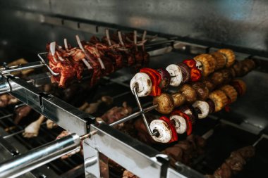 Kaburga, mantar, mısır, soğan ve kırmızı biber elektrikli ızgarada pişirilir. Lokantada mutfak malzemeleri.