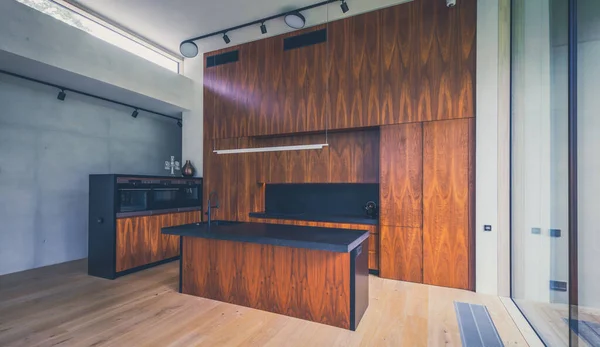 Интерьер современной деревянной кухни со встроенной техникой в доме. — стоковое фото
