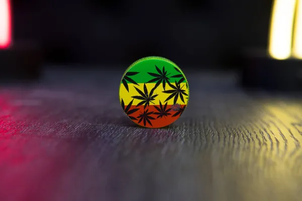 stock image Close-up of grinder with symbols of marijuana.