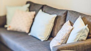 Yumuşak yastıklı rahat kanepeye yakın çekim. Modern apartman dairesi. Oturma odasındaki mobilyalar..