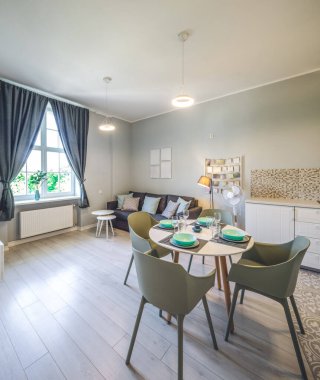 Modern stüdyo dairesinin modern iç mekanı. Oturma odasında mobilyalar var. Yemek masası ve sandalyeler.