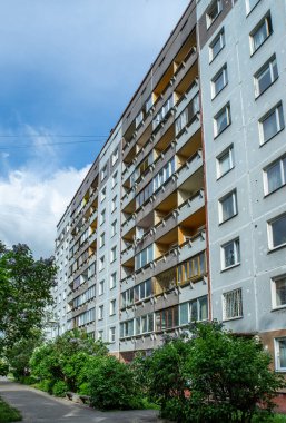 Riga, Letonya 'da çok katlı bir bina ön cephesi. Tipik Sovyet sonrası şehir mimarisi. Bahçedeki yeşil ağaç.