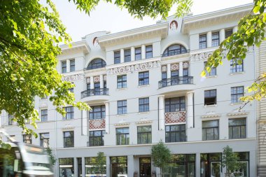 Riga, Letonya 'nın modern mimarisi. Binaların cephesi. Yeşil yapraklı dallar.