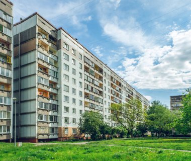 Riga, Letonya 'da çok katlı bir bina ön cephesi. Tipik Sovyet sonrası şehir mimarisi. Bahçedeki yeşil ağaç.