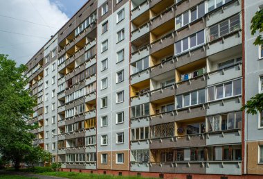 Riga, Letonya 'da çok katlı bir bina ön cephesi. Tipik Sovyet sonrası şehir mimarisi. Bahçedeki yeşil ağaç.