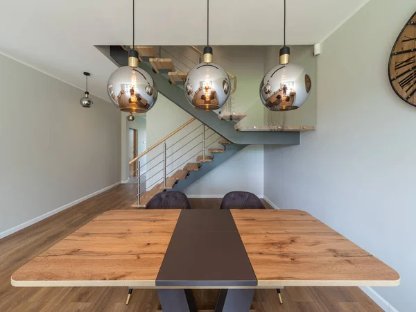 Intérieur moderne de maison privée. Lampes rondes au-dessus de table en bois. — Photo