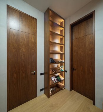 Modern iç mekan. Ayakkabılar için aydınlatılmış ahşap raflar.