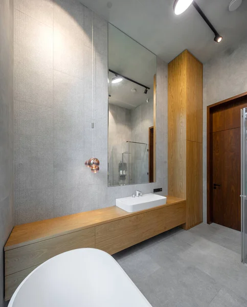 Interno del bagno in appartamento di lusso. Design grigio e legno. Lavello bianco. — Foto Stock