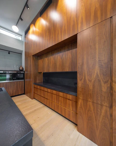 Современный интерьер деревянной кухни с черным счетчиком. Встроенная печь. — стоковое фото