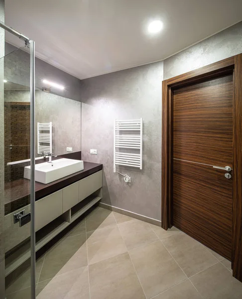 Moderne Einrichtung des Badezimmers. Holztür. Weißes Waschbecken. — Stockfoto