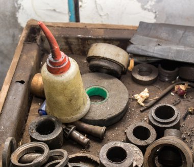 Garajda kirli çelik parçası üzerinde petrol şişe