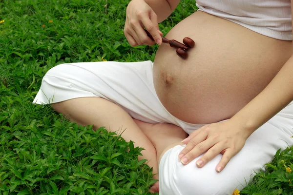 Pregnant mom with wooden massage — Stock Photo, Image