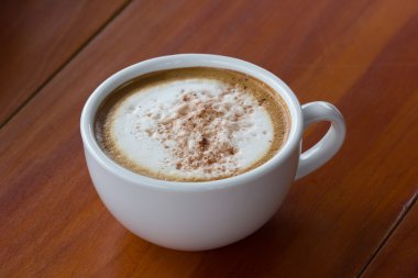 capuchino ahşap zemin üzerinde beyaz bir fincan kahve bir fincan.