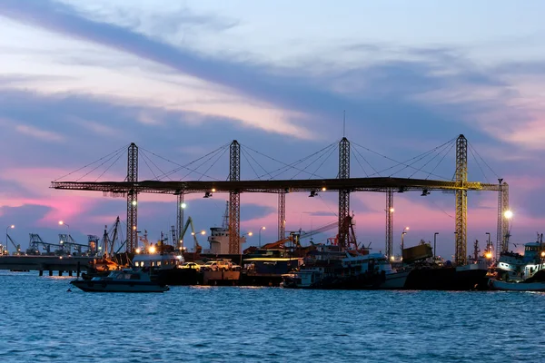 Dämmerung Container-Frachtschiff mit funktionierender Kranbrücke — Stockfoto