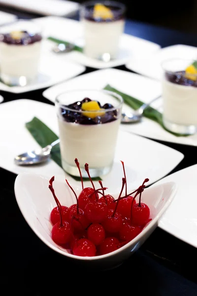 Třešeň maraschino v bílém cup s pozadím jogurt lichotník — Stock fotografie