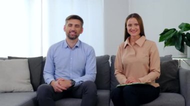 Gülümseyen kadın psikolog ve koltukta oturan mutlu adam.