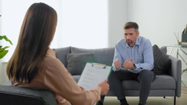 Boos emotionele man patiënt met geestelijke gezondheidsproblemen praten met therapeut — Stockvideo