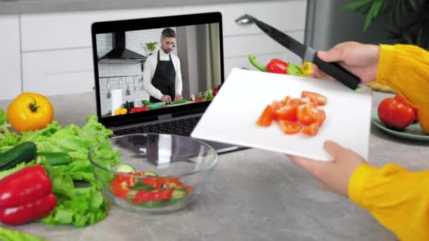 Ama de casa en cuchillos de cocina en rodajas de tomate de la tabla de cortar en ensaladera — Vídeo de stock