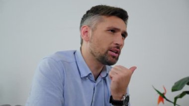 Ruh sağlığı yerinde sinirli, yetişkin sakallı bir adam kanepeye oturup doktor psikoterapistle konuşuyor. Psikiyatrist, klinikteki psikoterapi seansında hasta dinledi.